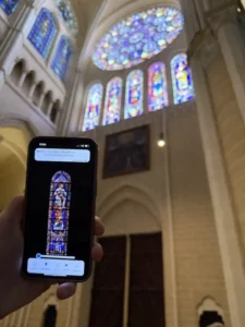 Utilisation de l'application Lire les vitraux de Chartres devant un vitrail de la cathédrale